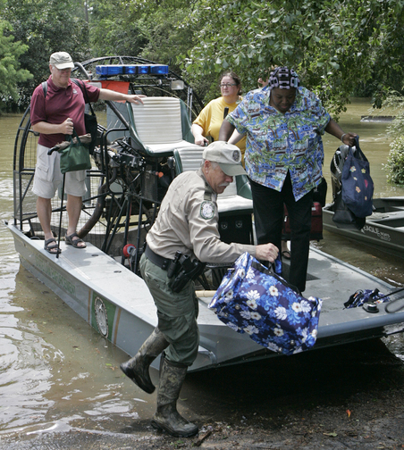 Algussie Thompson is helped ashore by Fish and Wildlife officer Charles Higman after Tropical Storm Fay flooded her Timber Lake neighborhood on Sunday, Aug. 24, 2008 in Tallahassee, Fla. photo: AP/Steve Cannon