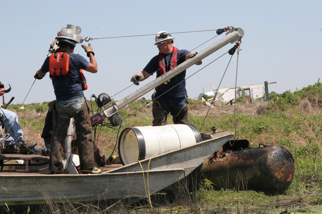 airboat with deck-mounted hoist recovering propane tank