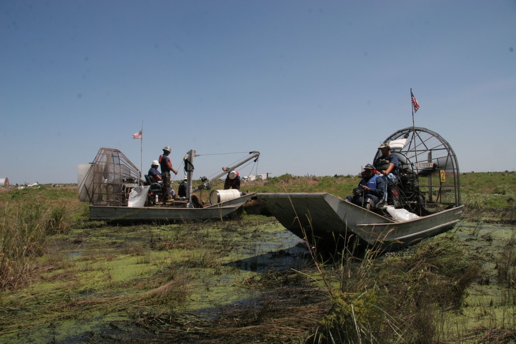 Airboat recovery crews haul out propane tanks and 55 gallon tank