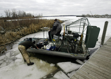 Mike Dobson, and co-worker Mike Russell travel on the Muskegon Lake ice from the Grand Trunk boat launch ramp on Muskegon Lake, Michigan on Monday, March 25, 2013 on Russell's airboat. Russell, owner of Russell Marine Engineering based in Muskegon, and Dobson set out to drill holes through the ice to gather soil samples on the lake bottom for a client.